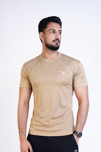 Man wearing a beige t-shirt and black pants on a white background